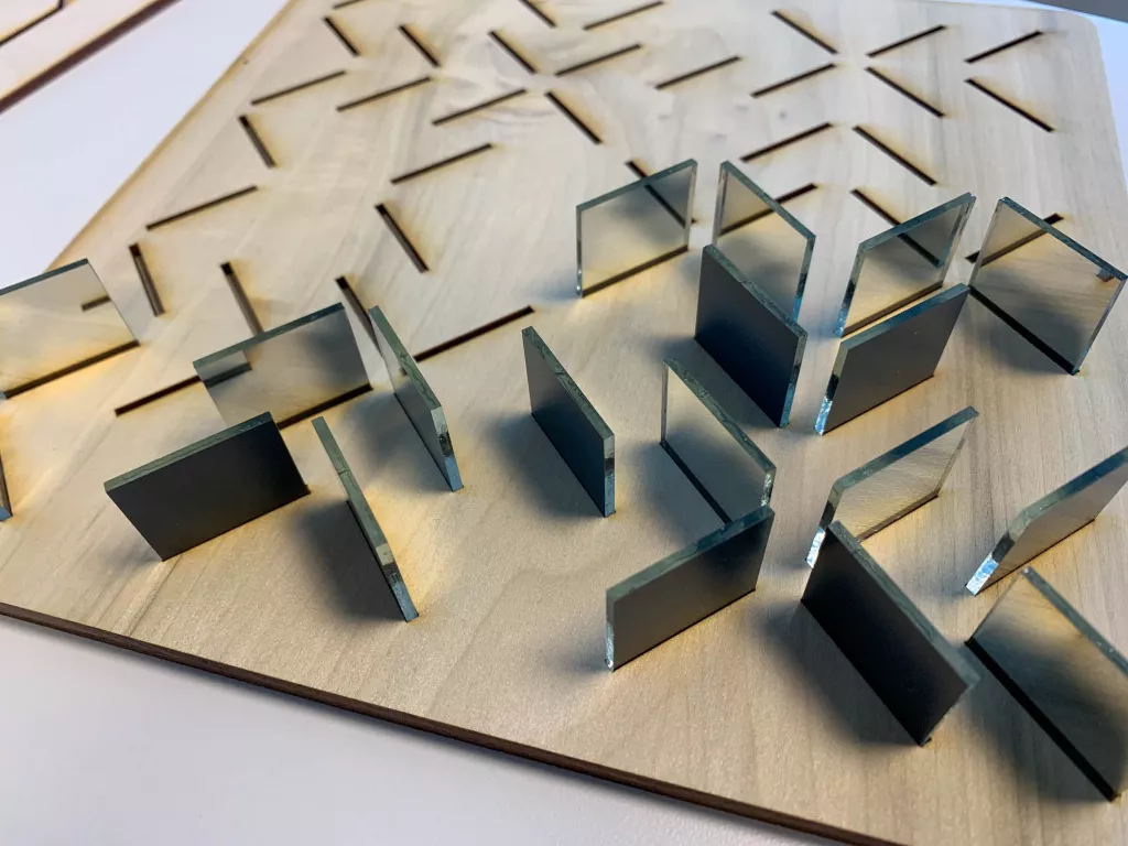 Assembling the labyrinth. The top layer has slits precisely cut to hold the 52 mirrors in such a way that the back sides of the mirrors were on the appropriate diagonals.